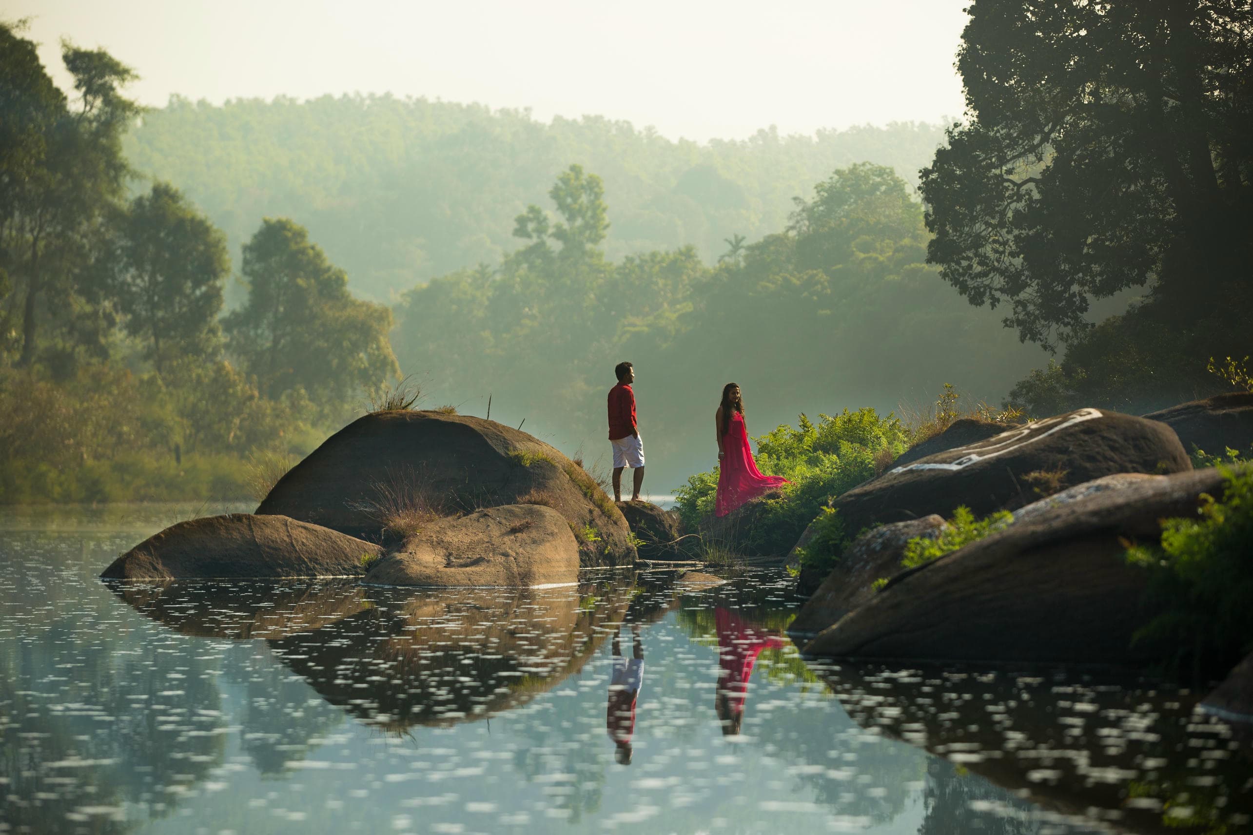 Couple posing near lakeside reflection